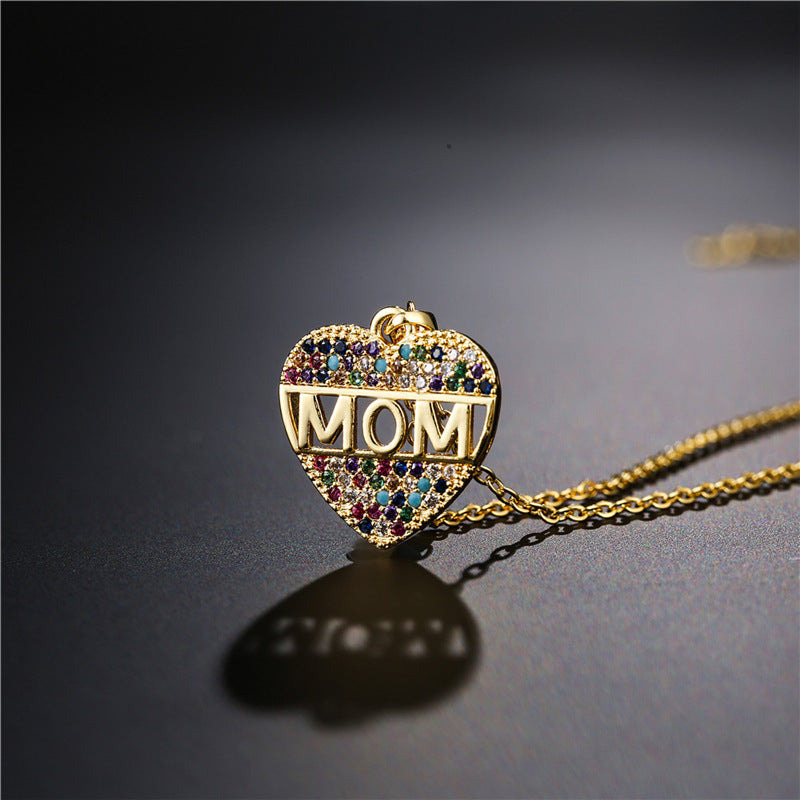Gold heart MOM pendant necklace on a black canvas