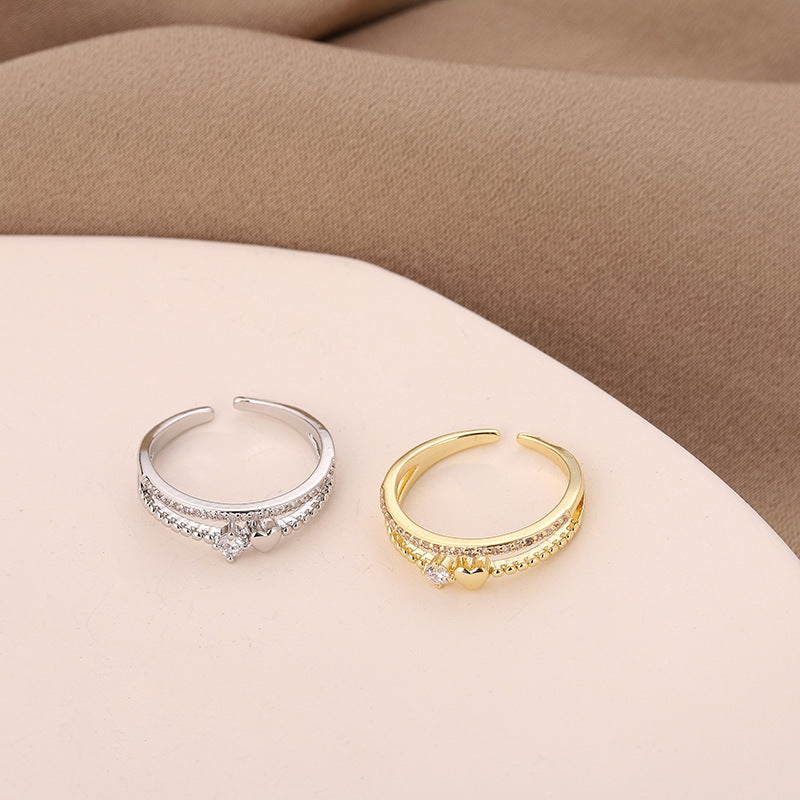A gold and a silver heart shaped ring over a table