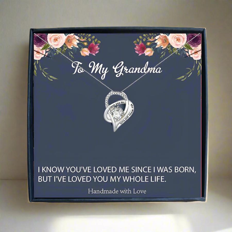 someone holding a card box with a silver heart necklace for grandma