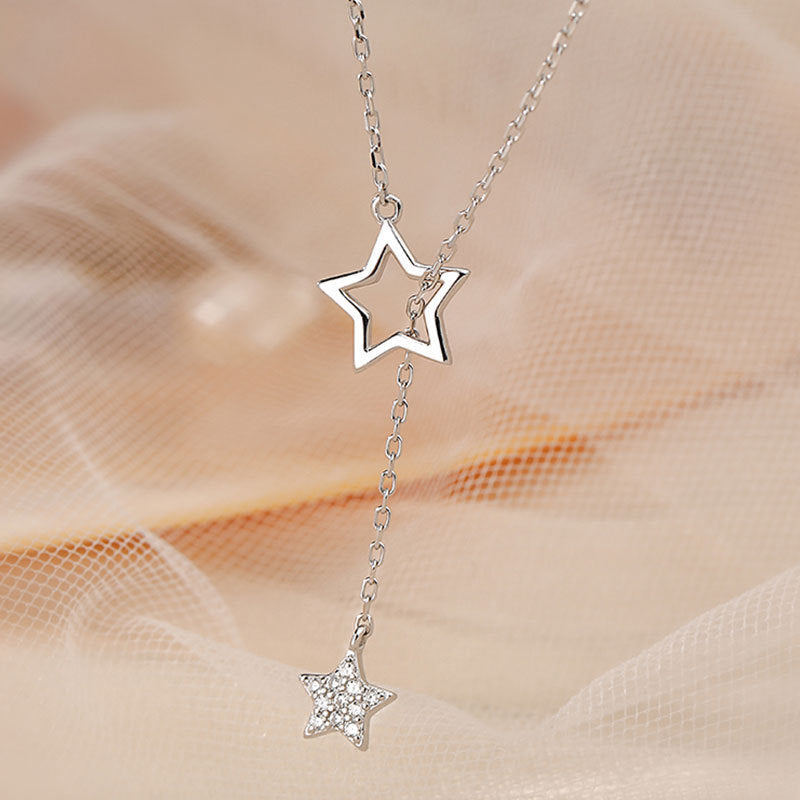 beautiful silver-diamond-start tassel necklace on a beige fabric