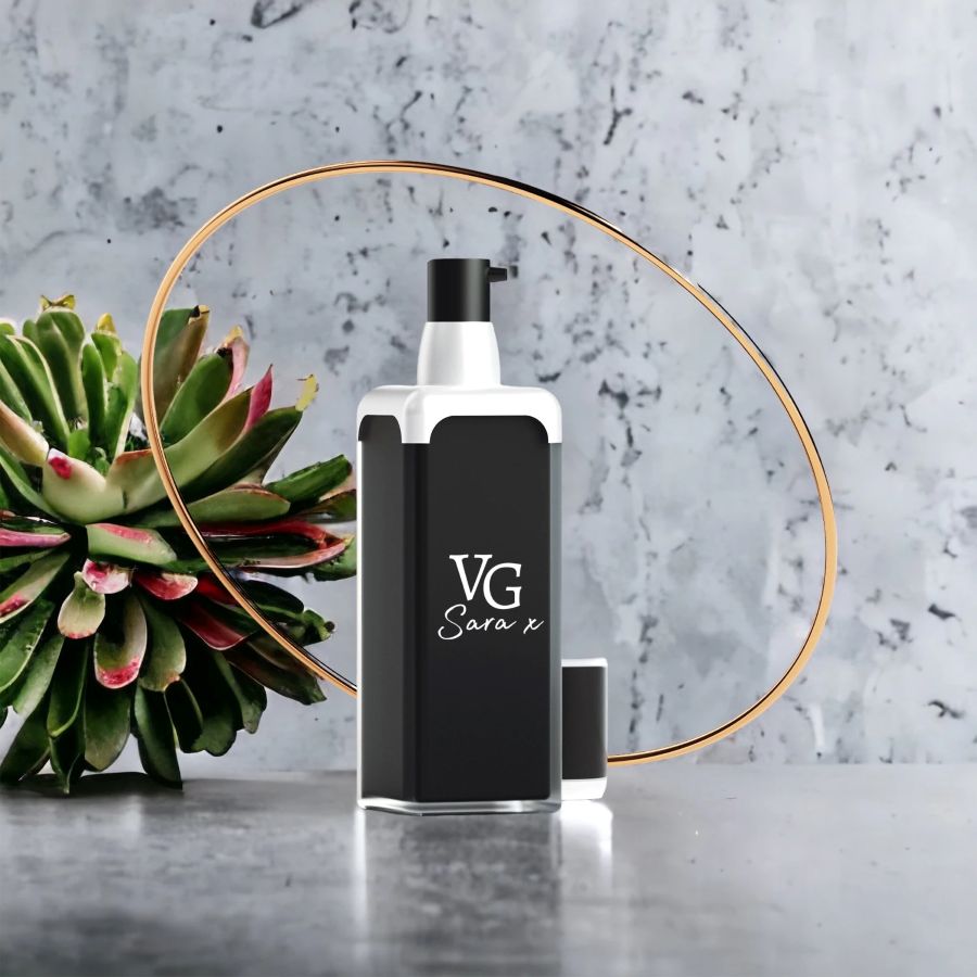 Black and white bottle of serum with a Logo brand VG Sara x on a grey marble countertop beside cactus
