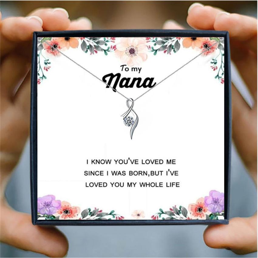 someone holding a card box with a silver heart necklace for nana