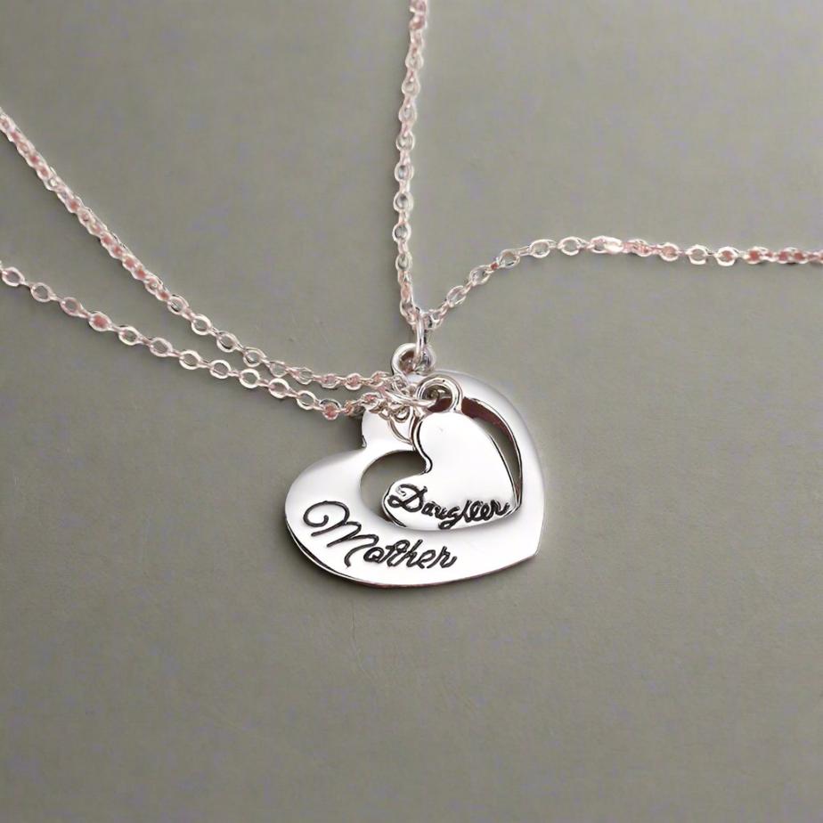 2 silvers hearts for mother and daughter on a salmon silk surface