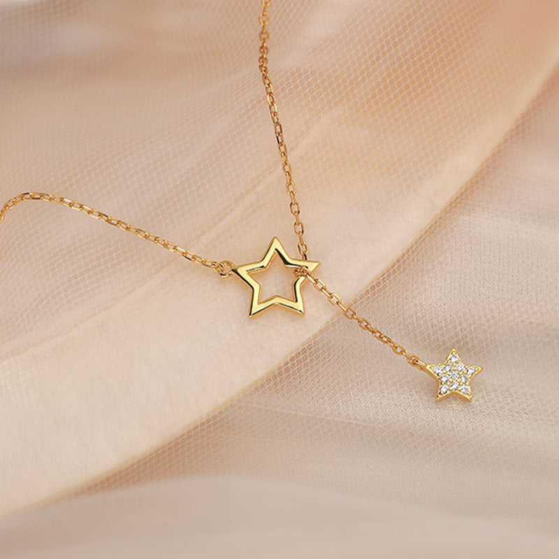 Elegant diamond start gold necklace on a fabric canvas