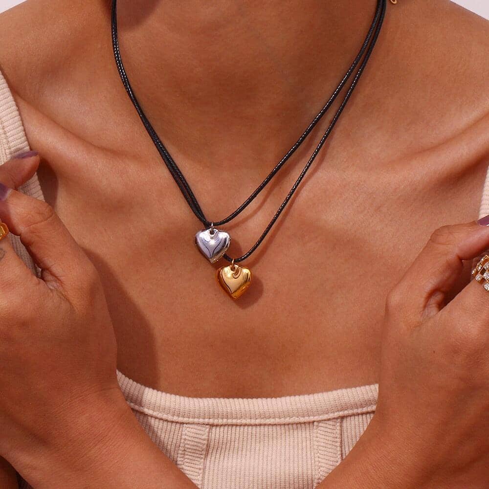 A woman wearing a silver and a gold necklace
