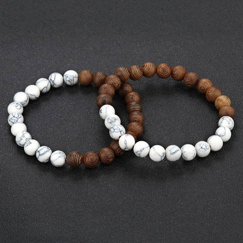 a pair of white and natural wood bead bracelet on a black canvas