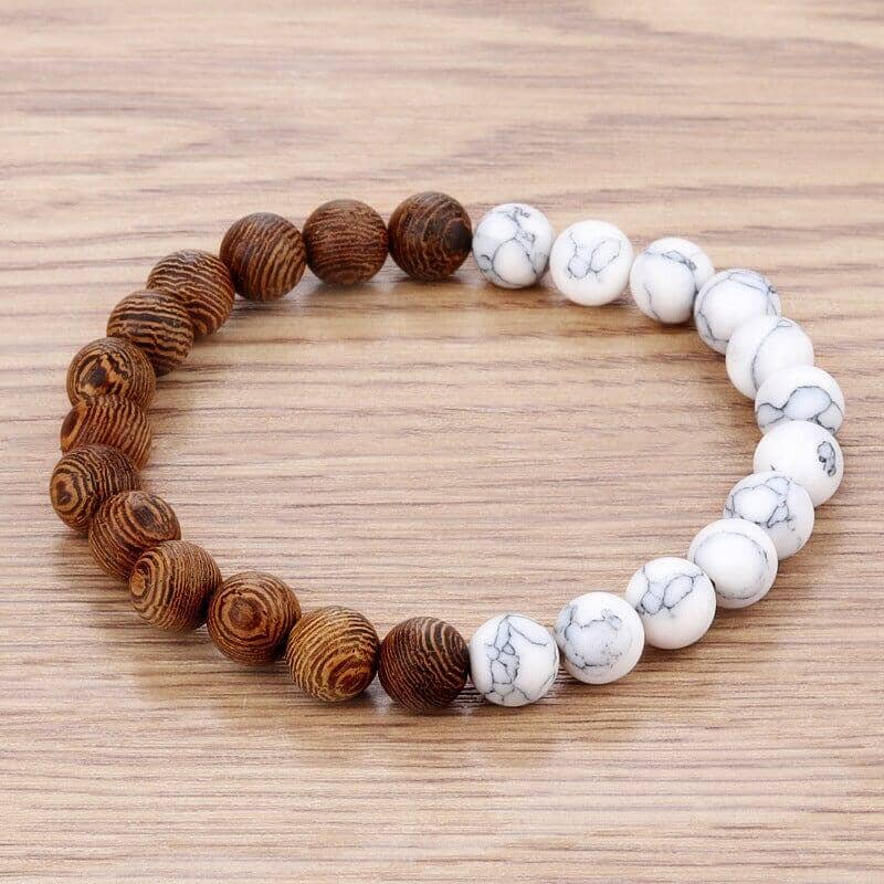a white and natural wood bead bracelet over a wooden surface