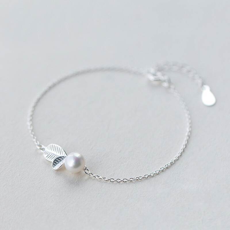 Elegant bracelet with a leaf and a pearl design, silver color