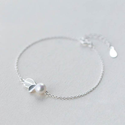 Elegant bracelet with a leaf and a pearl design, silver color