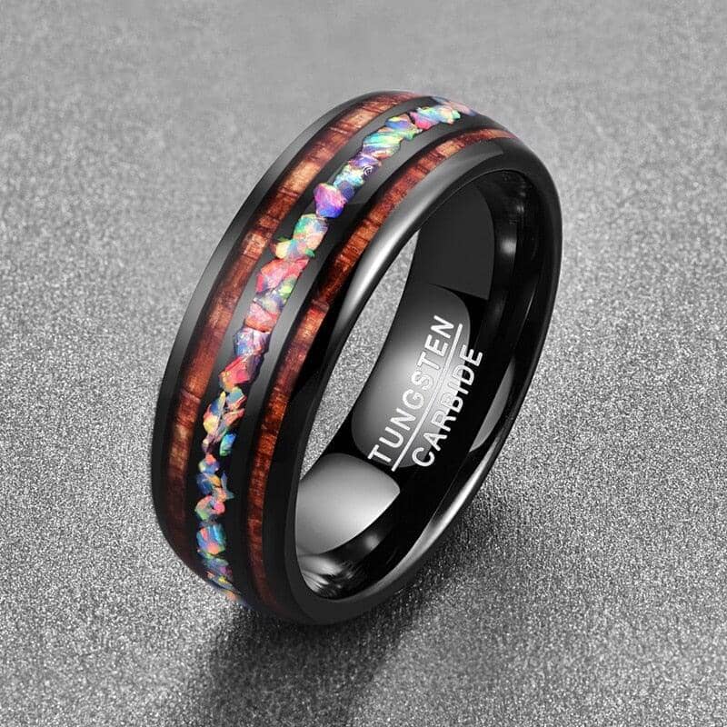 Luxurious Black and Gold Tungsten Carbide Ring with an intricate opal inlay design in a grey background