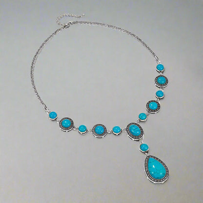 “An eco-friendly, polished alloy necklace featuring a water drop-shaped pendant with blue turquoise gemstones