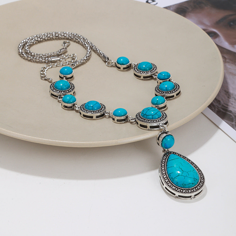 an alloy necklace with turquoise gems stones over a beige plate