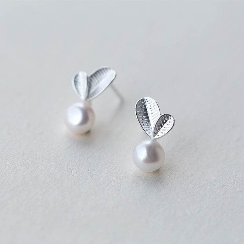Pair of earring studs with a leaf and a pearl design