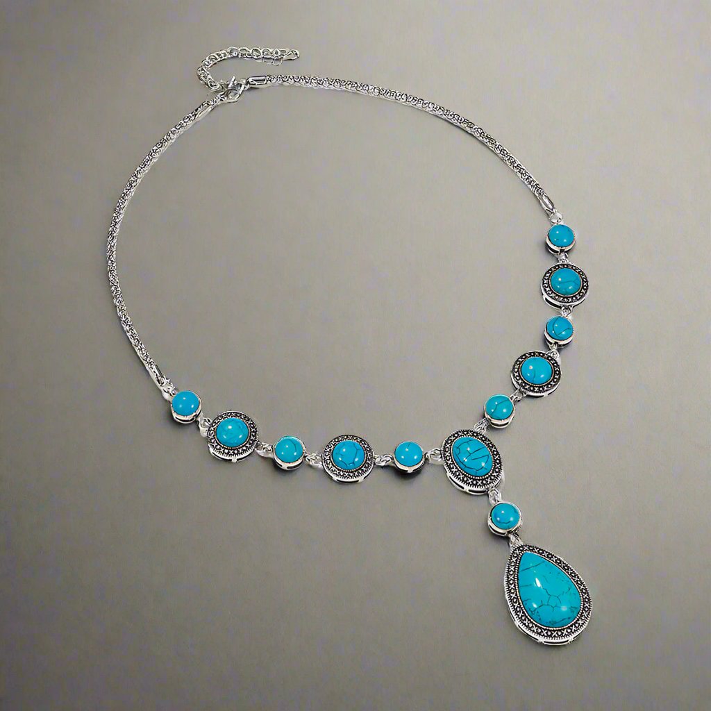 “An eco-friendly, polished alloy necklace featuring a geometric shaped pendant with blue turquoise gemstones