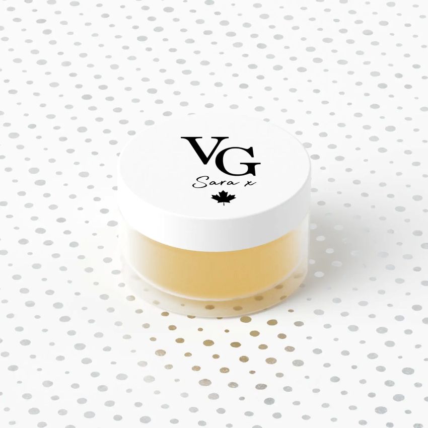 Jar of cream with a white lid featuring 'VG' branding on a polka dot background