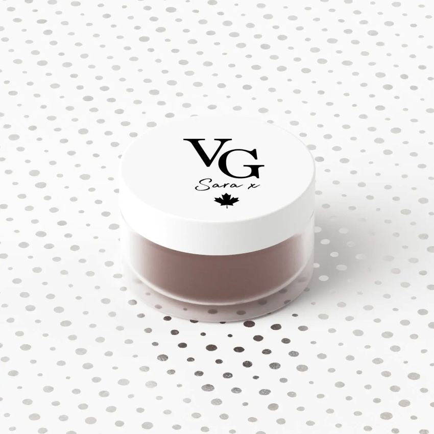 Cosmetic container with 'VG Sara x' branding on a polka dot background